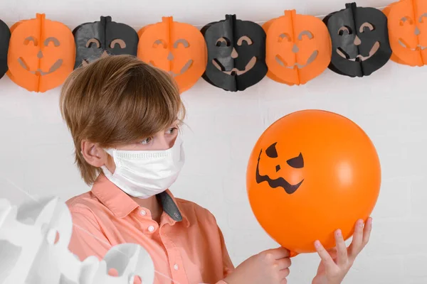 Ein Blonder Junge Medizinischer Schutzmaske Der Auf Orangefarbene Luftballons Blickt — Stockfoto