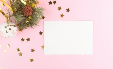 Noel kartı modelleme şablonu, köknar dalları, altın yıldızlar ve pembe pastel arka planda şenlikli dekorasyon. Yılbaşı ve Yeni Yıl için tasarım öğesi.