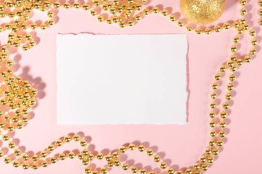 Christmas card mockup template with golden festive decoration on a pink pastel background. Design element for Christmas and New Year congratulation, rsvp, thank you, greeting or invitation card