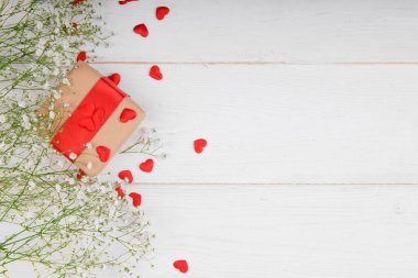 Beyaz arka planda kırmızı kalpler olan hediye kutusu küçük beyaz çiçekler, Sevgililer Günü, bayram, evli çiftin yıldönümü, doğum günü geçmişi.