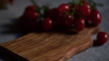 Kadın eli kesme tahtasına küçük bir mozzarella peyniri dolu bir kase koyar.