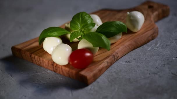 Ruka Dává Čerstvá Rajčata Řezací Prkno Malými Kuličkami Mozzarella Sýra — Stock video