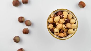 Kasede soyulmuş fındıklar ve beyaz ahşap arka planda fındıklar, üst manzara, yakınlaştır.