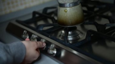 Bir kız mutfakta İtalyan moka demliği ile kahve espresso hazırlar, sabah kahve ruloyu iyi bir uyku için, 7. adım, kadın elinin kapağı ocakta gaz yakmaktır.