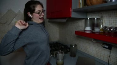 Bir kız mutfakta İtalyan moka demliği ile kahve espresso hazırlıyor, sabah kahve ruloyu iyi bir şekilde uyanıyor, beşinci adım, kız esniyor, bir moka alıyor ve sobaya koyuyor, gazı yakıyor.
