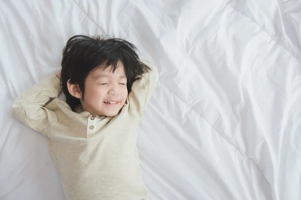 Asiatiska barn liggande på vit säng — Stockfoto