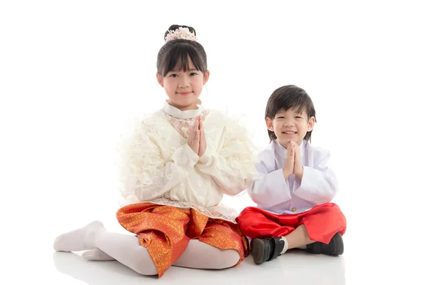 Šťastné děti v thajské tradiční oblek sedí na bílém pozadí — Stock fotografie