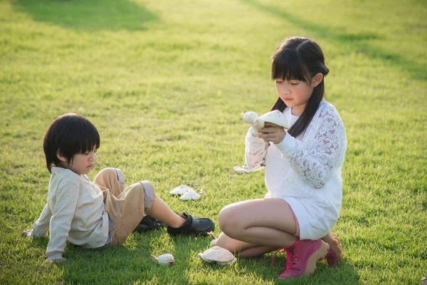 Niños asiáticos recogiendo setas en el parque — Foto de Stock