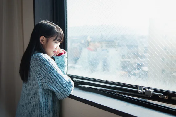 Menina olhando para a janela — Fotografia de Stock