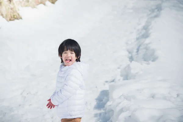 在冬天的衣服与雪背景的亚洲男孩 — 图库照片