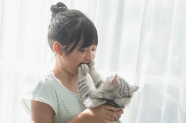 Asyalı kız Amerikalı stenografi kedi ile oynarken