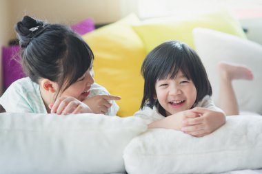 Asya çocuk beyaz yatakta yatarken