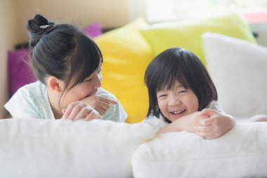 Asya çocuk beyaz yatakta yatarken