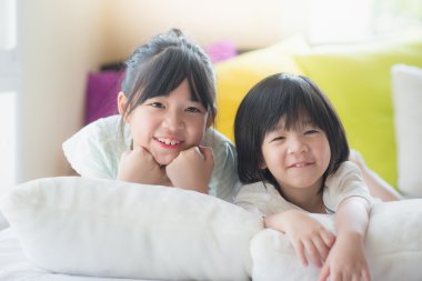 Asya çocuk beyaz yatakta yatarken