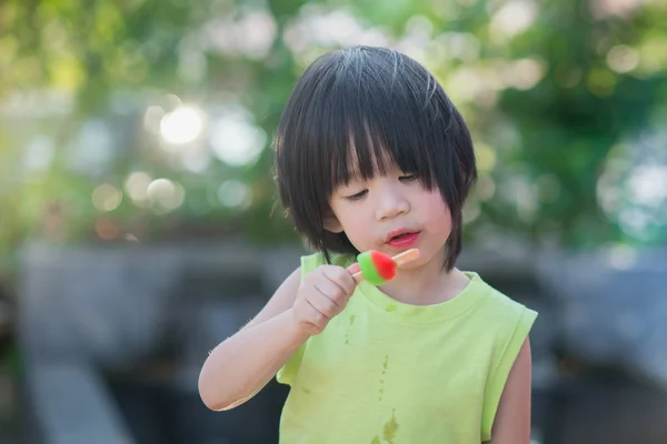 Asian child eating an ice cream outdoors — Stock Photo, Image