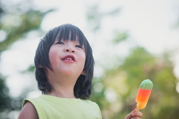 Asiatiska barn äta en glass utomhus — Stockfoto