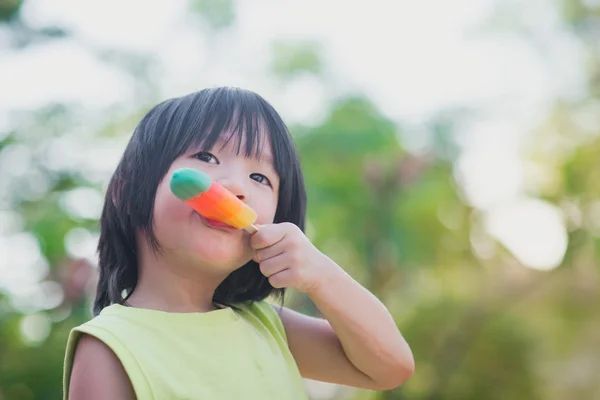 Asiatisches Kind isst ein Eis im Freien — Stockfoto