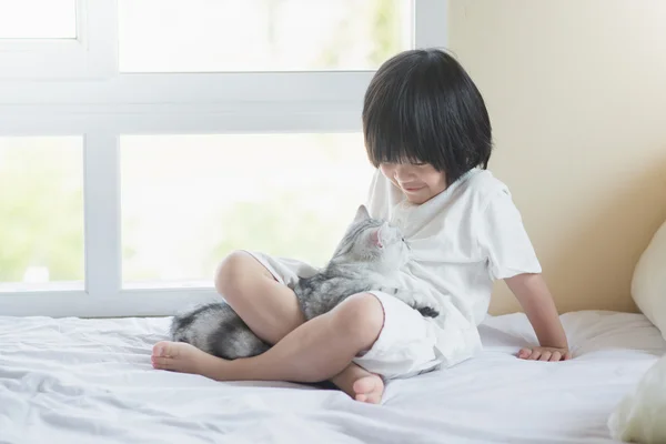 Asiático bebé jugando con americano taquigrafía gatito —  Fotos de Stock