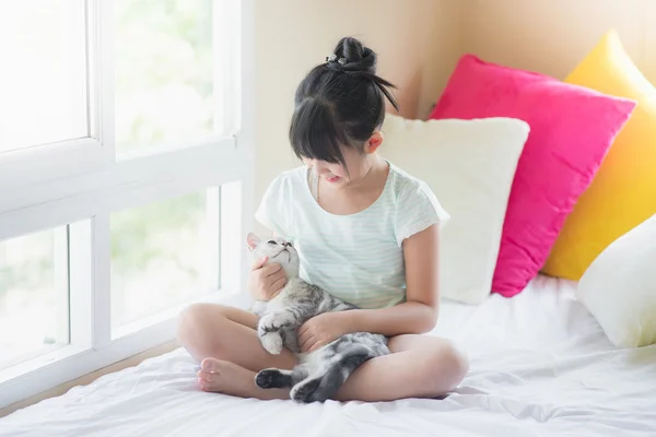 Belle asiatique fille jouer avec américain shorthair chat sur l 'lit — Photo