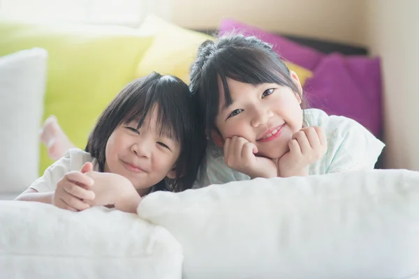 Asian children lying on white bed — Stock Photo, Image