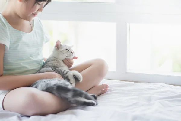 Hermosa chica asiática jugando con american shorthair gato en la cama — Foto de Stock