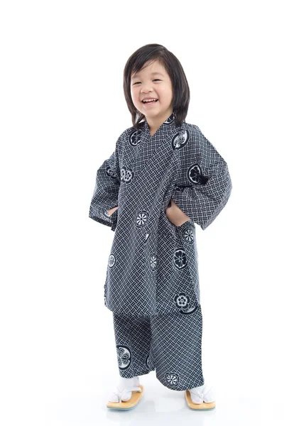 Счастливый азиатский мальчик в кимоно стоит на белом фоне — стоковое фото