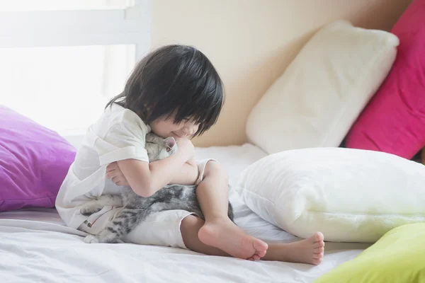 Азиатский ребенок играет с американским короткошерстным котенком — стоковое фото