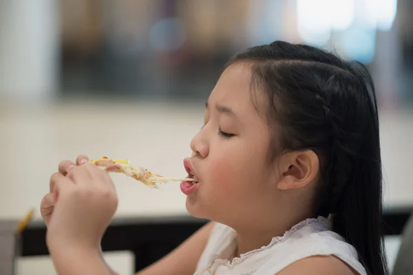 Дівчина їсть шматочок піци в кукурудзі — стокове фото