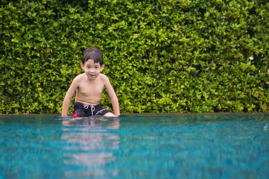 Asyalı çocuk yüzme havuzunda oynayan