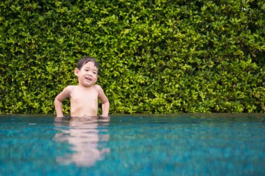 Asyalı çocuk yüzme havuzunda oynayan