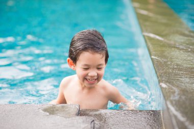 Asyalı çocuk yüzme havuzunda oynayan
