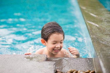 Asyalı çocuk yüzme havuzunda oynayan