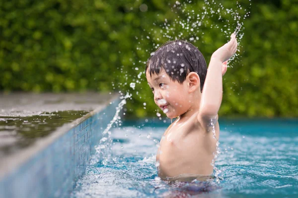 Asyalı çocuk yüzme havuzunda oynayan