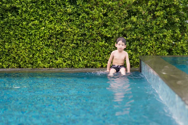 Asyalı çocuk yüzme havuzunda oynayan