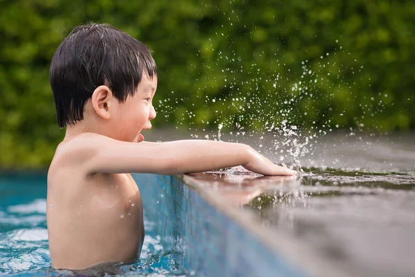 Asyalı çocuk yüzme havuzunda oynayan