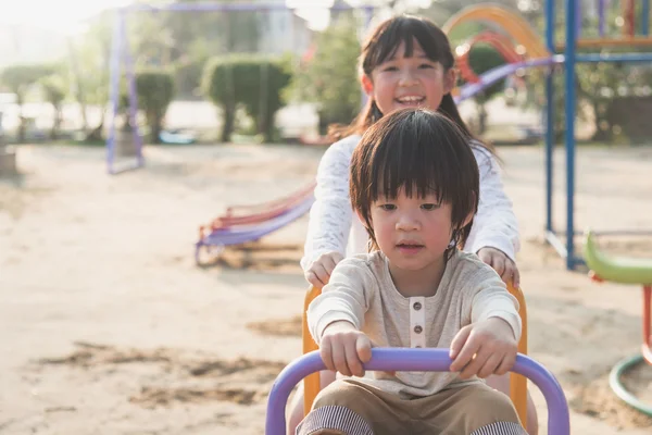 Süßes asiatisches Kind reitet Wippbrett auf dem Spielplatz — Stockfoto