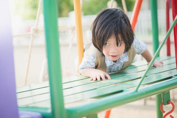 Criança brincando no parque infantil no verão parque ao ar livre — Fotografia de Stock