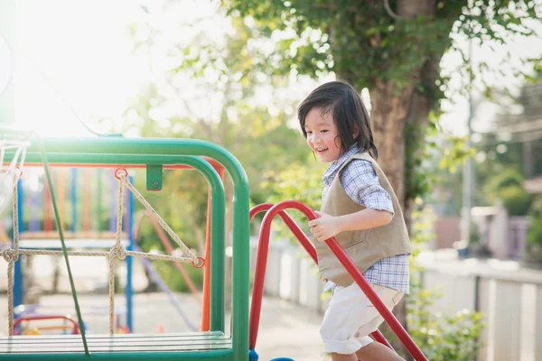 Criança brincando no parque infantil no verão parque ao ar livre — Fotografia de Stock