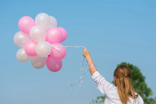 Frau hält viele Luftballons in der Hand — Stockfoto