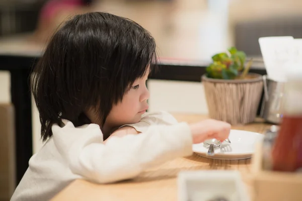 Asiático niño sosteniendo una cuchara y tenedor con — Foto de Stock