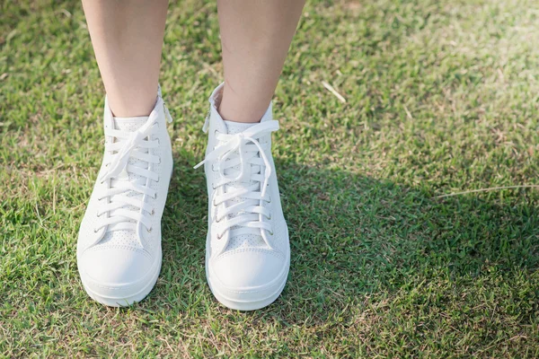 Vrouw in witte sneakers lopen in zonlicht — Stockfoto