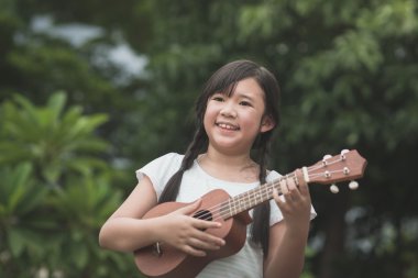 Güzel Asyalı kız oyun ukulele, 