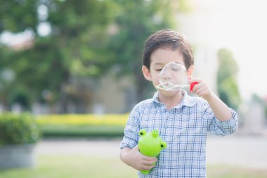 Şirin Asyalı çocuk sabun köpüğü üfleme