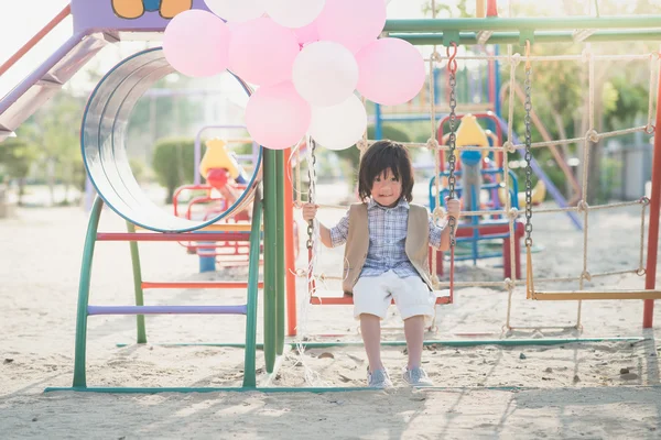 Asiatico bambino su un swing su estate giorno — Foto Stock