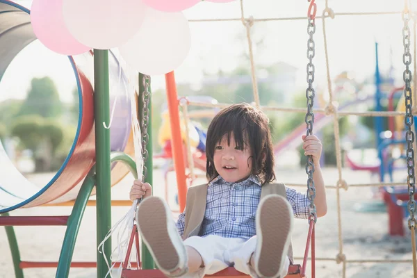 Asiatique enfant sur une balançoire sur été jour — Photo