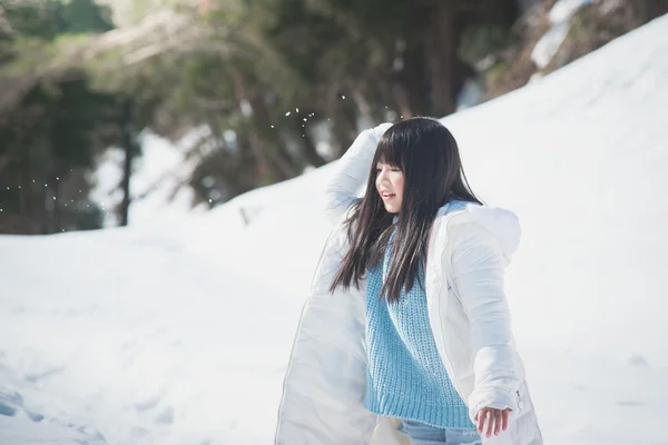 Menina asiática sorrindo ao ar livre na neve no frio dia de inverno — Fotografia de Stock