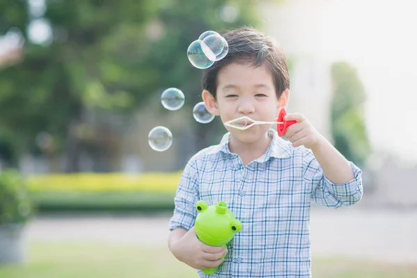 Söta asiatiska barn blåser en såpbubbla — Stockfoto