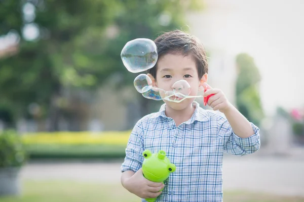 Bonito ásia criança é soprando um sabão bolha — Fotografia de Stock