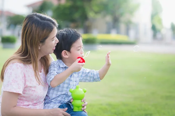 Asiático mãe e filho soprando bolhas — Fotografia de Stock