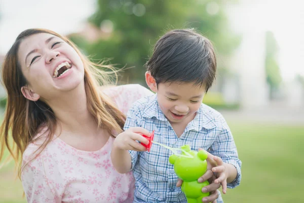 Asiática madre e hijo soplando burbujas — Foto de Stock